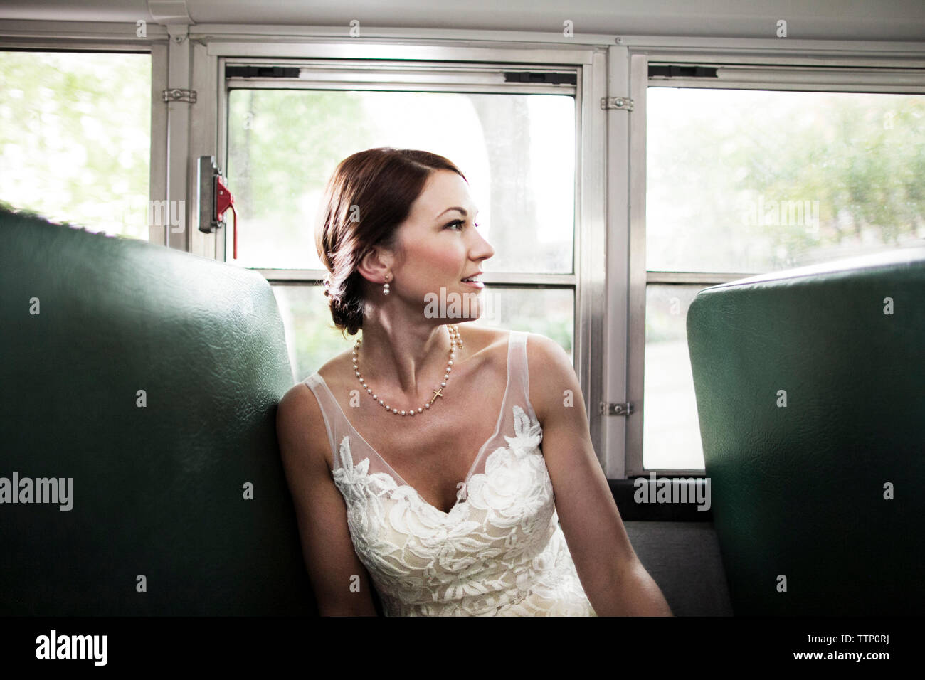 Felice donna seduta in treno contro windows Foto Stock