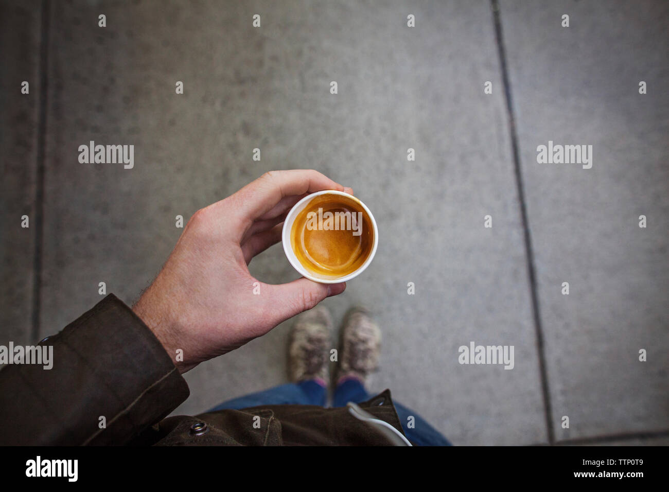 Sezione bassa dell uomo con caffè e permanente sulla strada Foto Stock