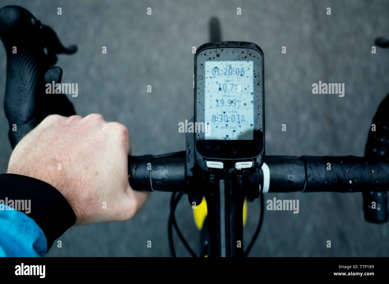 Close-up di uomo con bicicletta con annessa smart phone durante la stagione delle piogge Foto Stock
