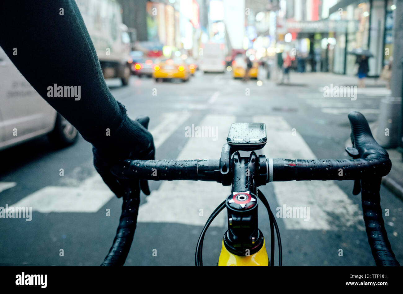 Immagine ritagliata dell'uomo ciclismo su strada in città durante la stagione delle piogge Foto Stock