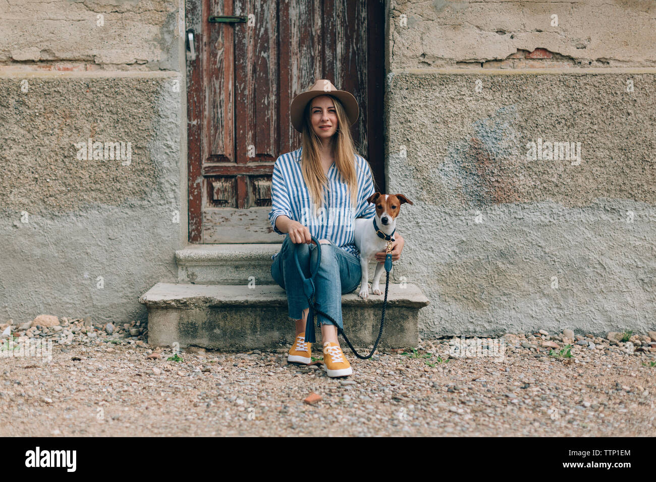 Ritratto di donna con Jack Russell Terrier seduto sulla parte anteriore stoop Foto Stock