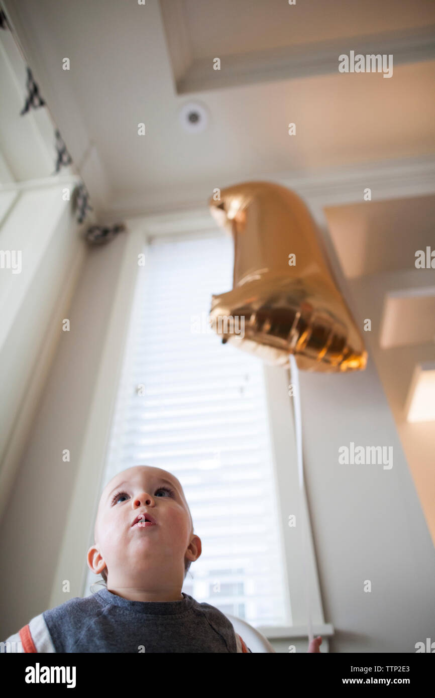Baby boy con palloncino elio a casa Foto Stock