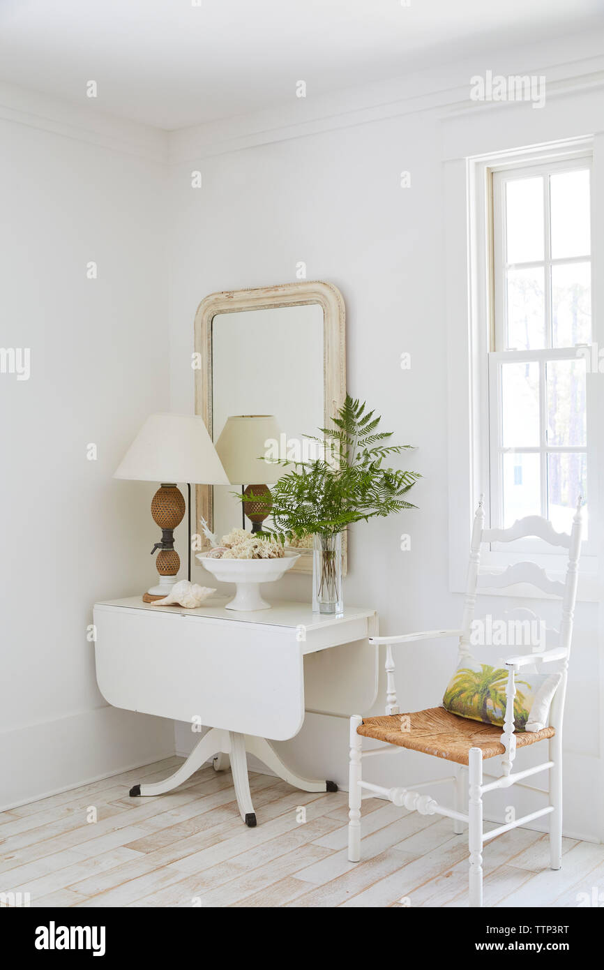 Tabella decorate e lo specchio dalla finestra nel beach cottage Foto Stock