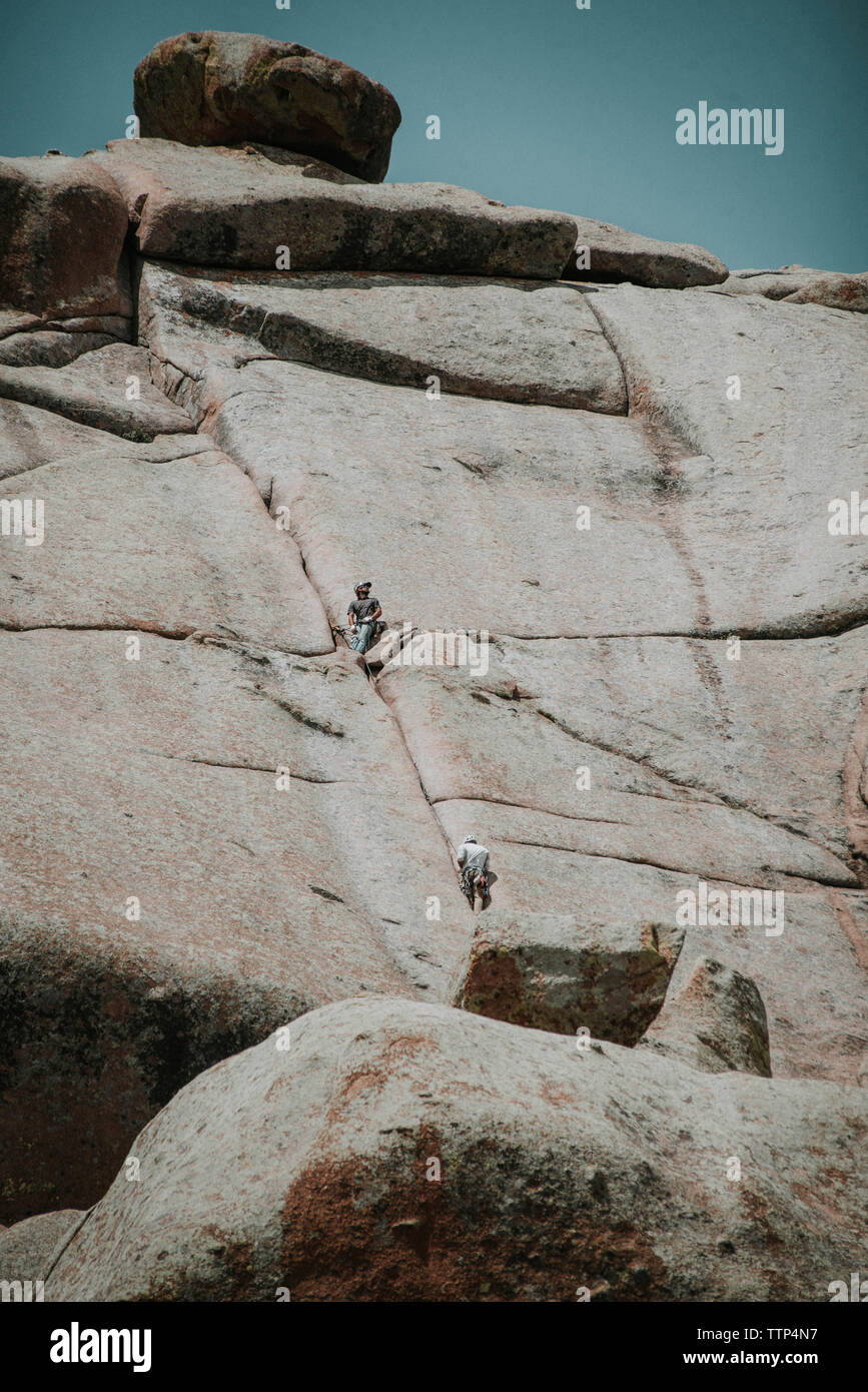Basso angolo di vista amici arrampicata in montagna Foto Stock