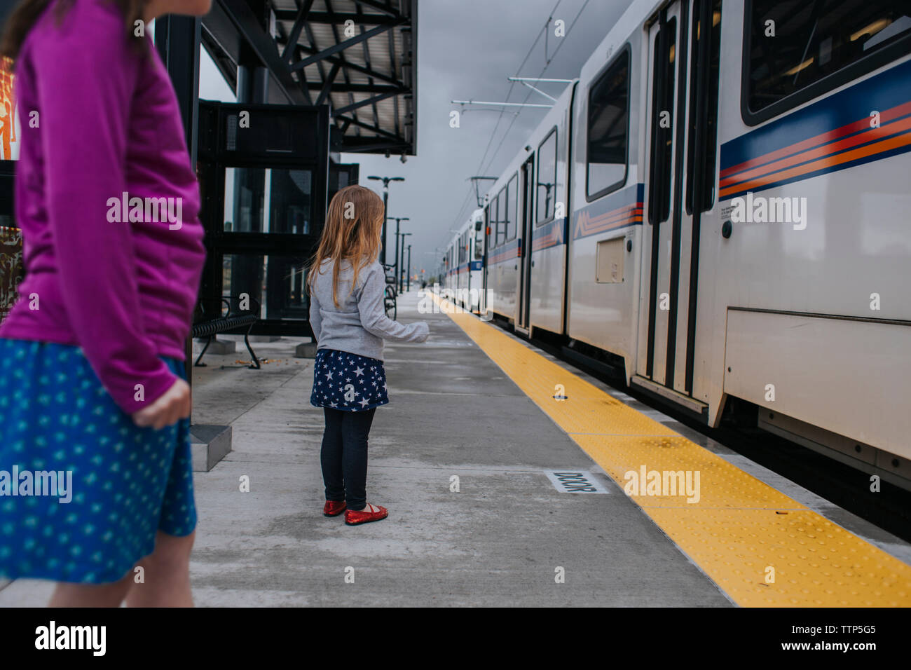 Sorelle in piedi alla stazione ferroviaria platform Foto Stock