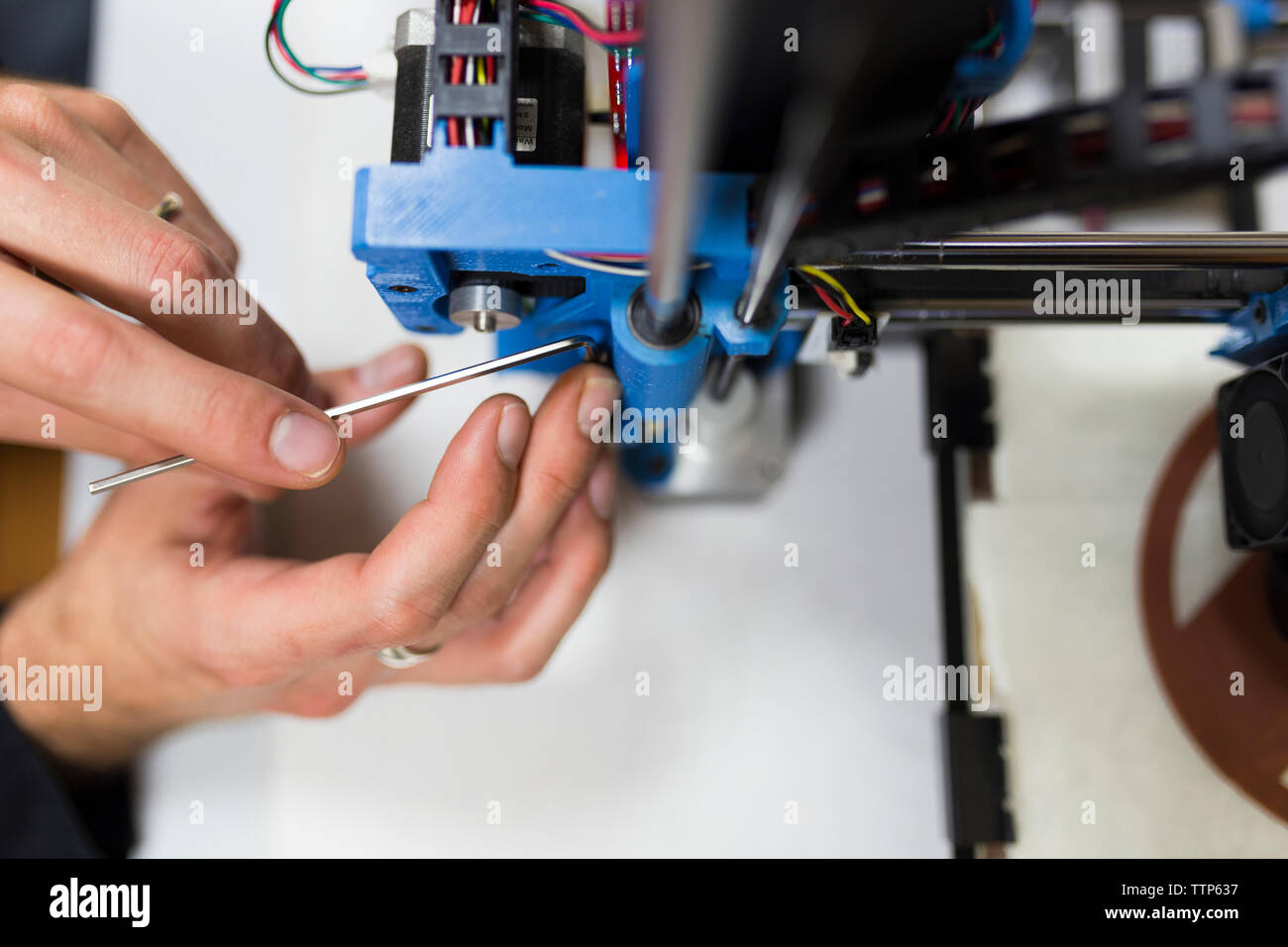 Mani tagliate di ingegnere il fissaggio stampante 3D sul tavolo Foto Stock
