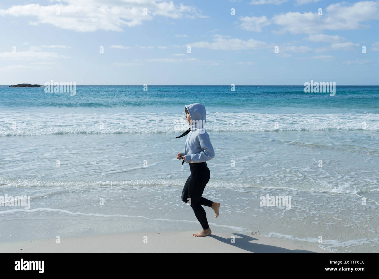 Donna asiatica in esecuzione sulla spiaggia di mattina Foto Stock