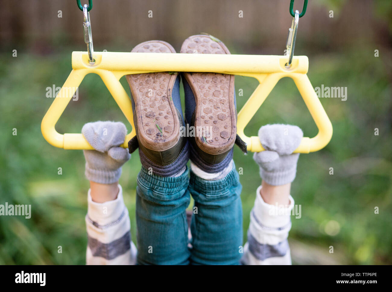 Sezione bassa del ragazzo giocoso appeso sul gioco all'aperto Attrezzature in cantiere Foto Stock