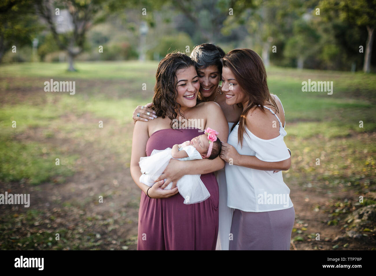 Felice multi-famiglia di generazione in piedi sul campo al park Foto Stock