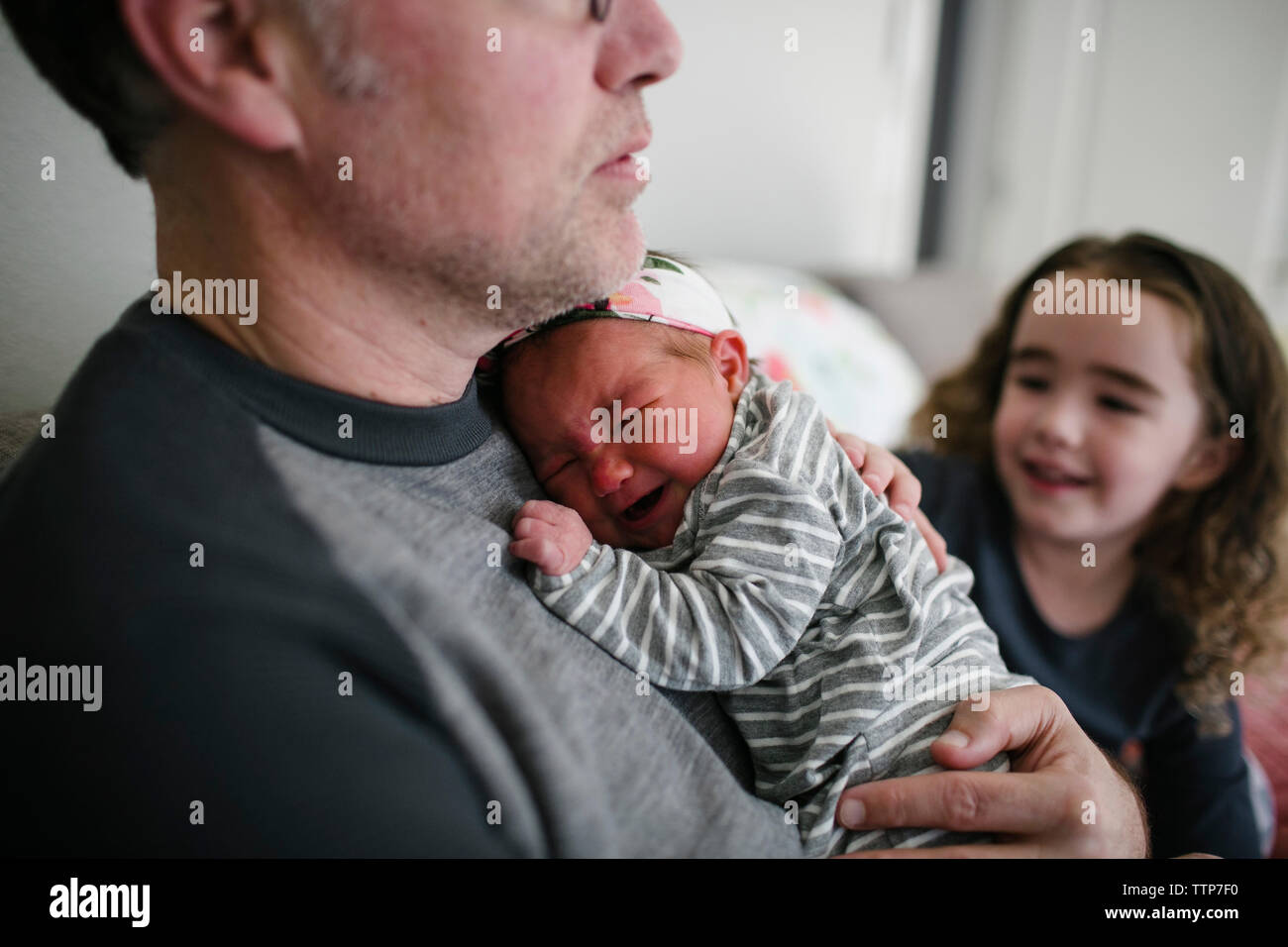 Padre consolante Gridando bambino ragazza dalla figlia a casa Foto Stock