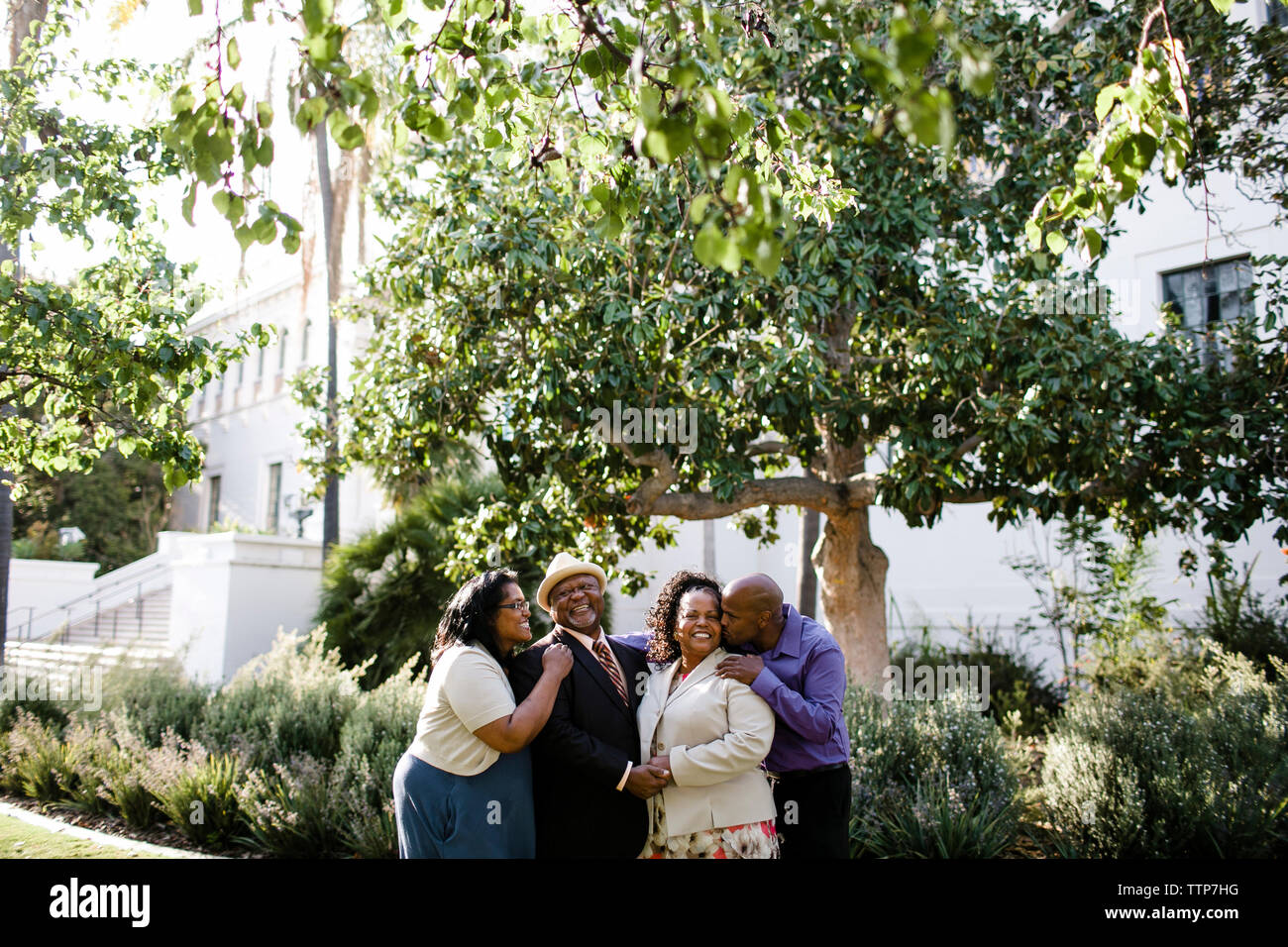 La famiglia felice in piedi da piante in posizione di parcheggio Foto Stock
