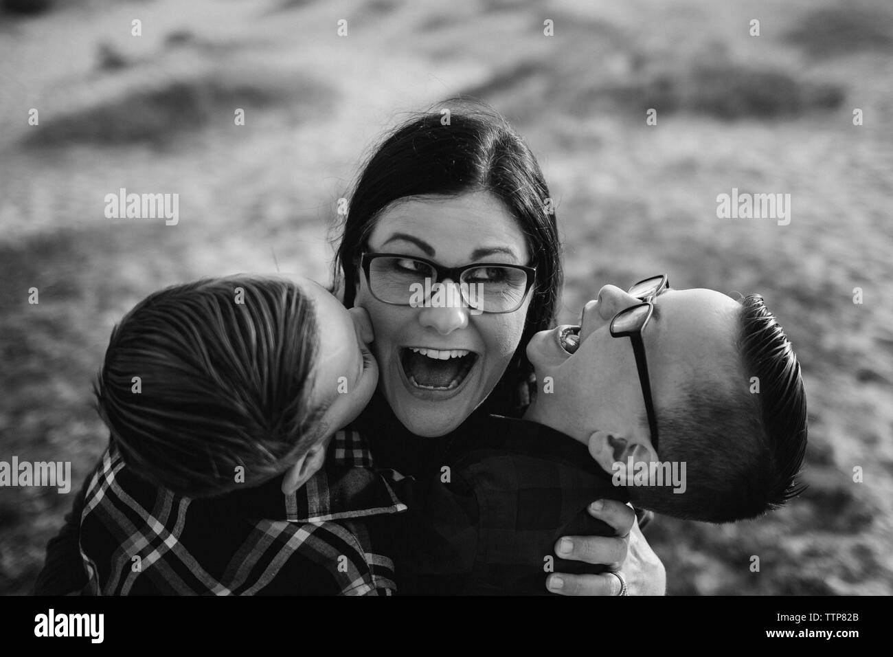 Elevato angolo di visione della madre felice godendo con graziosi figli presso la spiaggia durante il tramonto Foto Stock