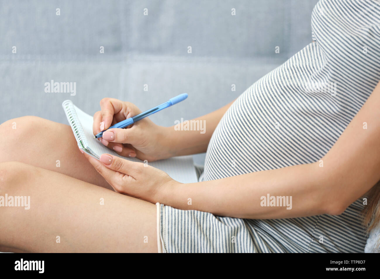 Donna incinta rendendo distinta di imballaggio per ospedale di maternità a casa Foto Stock
