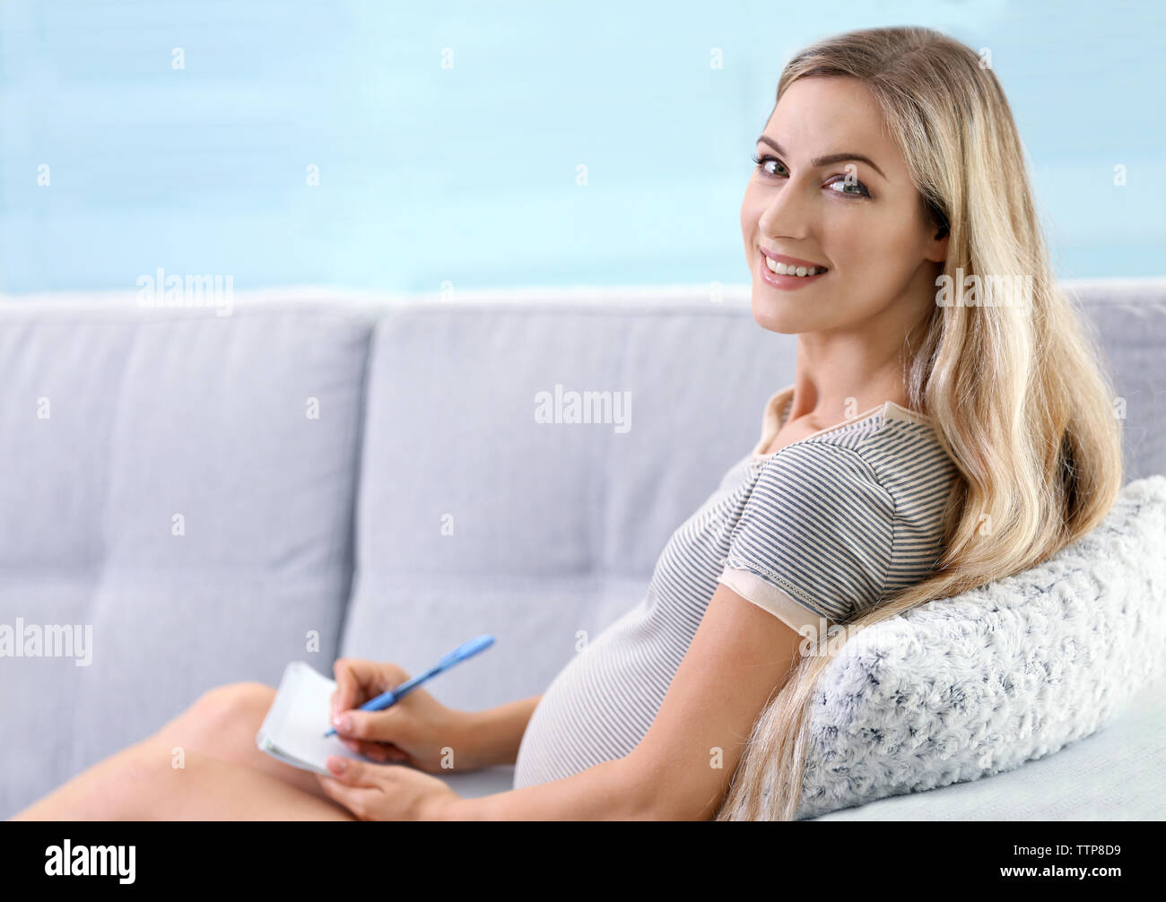 Donna incinta rendendo distinta di imballaggio per ospedale di maternità a casa Foto Stock