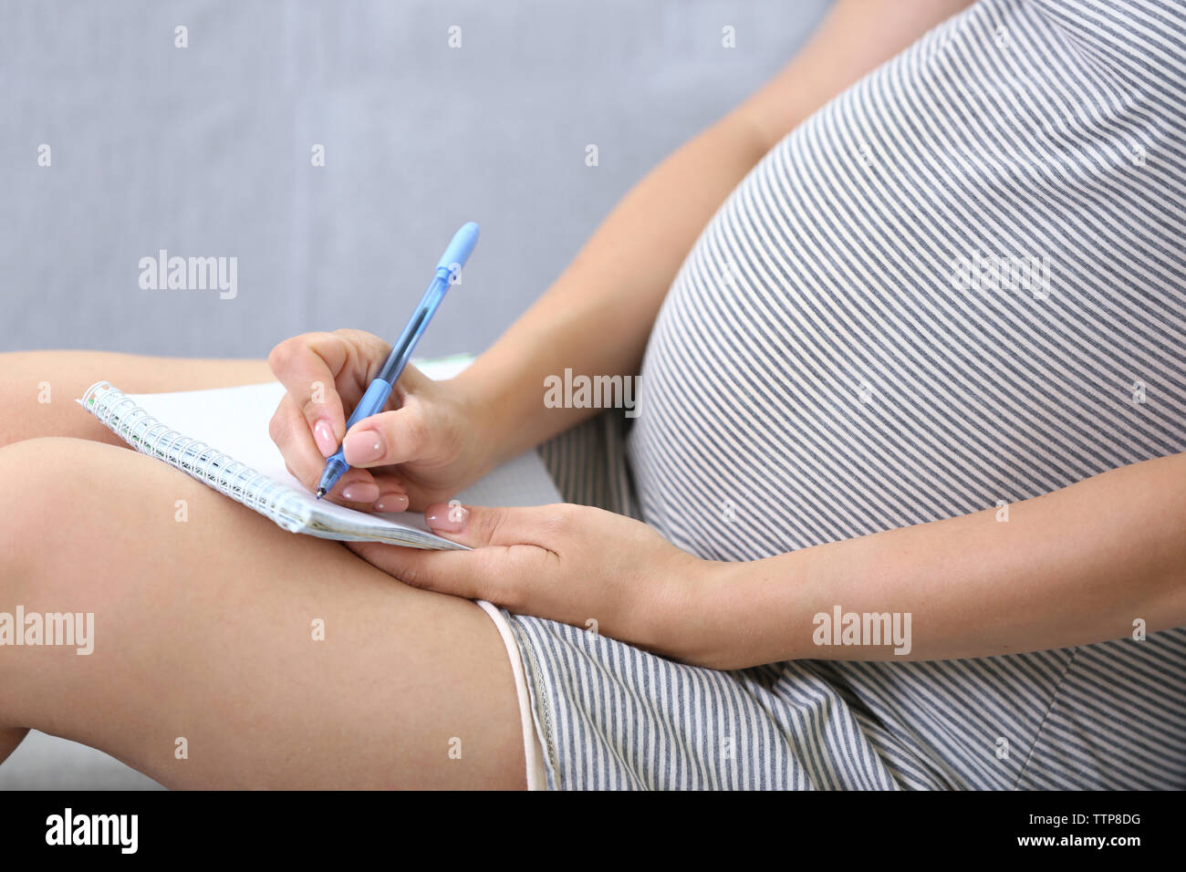 Donna incinta rendendo distinta di imballaggio per ospedale di maternità a casa Foto Stock
