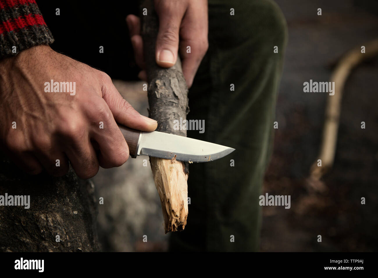 Immagine ritagliata dell uomo il taglio di legno sul campo Foto Stock