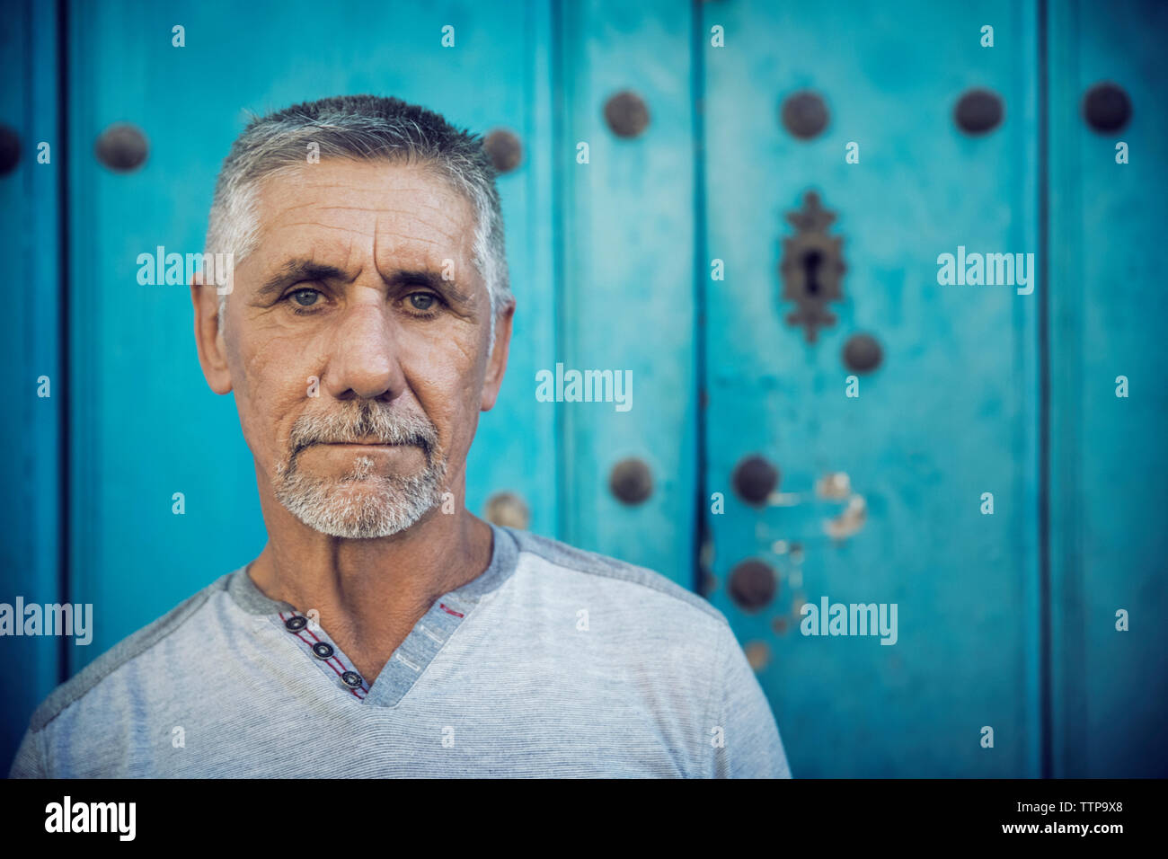 Ritratto di uomo in piedi contro la parete blu Foto Stock