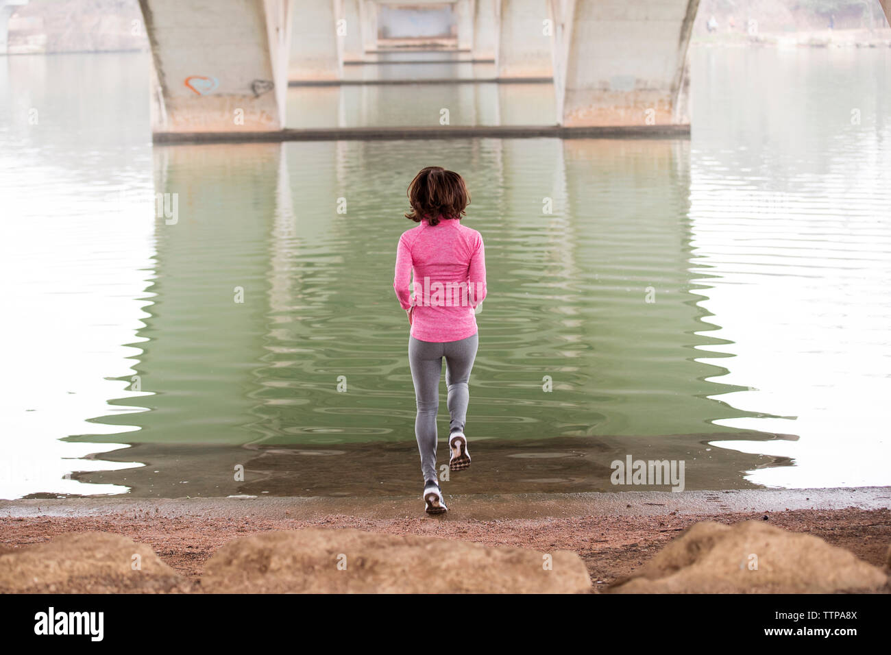 Vista posteriore della donna che si tuffa dal sottostante lago di Lamar Boulevard Bridge Foto Stock