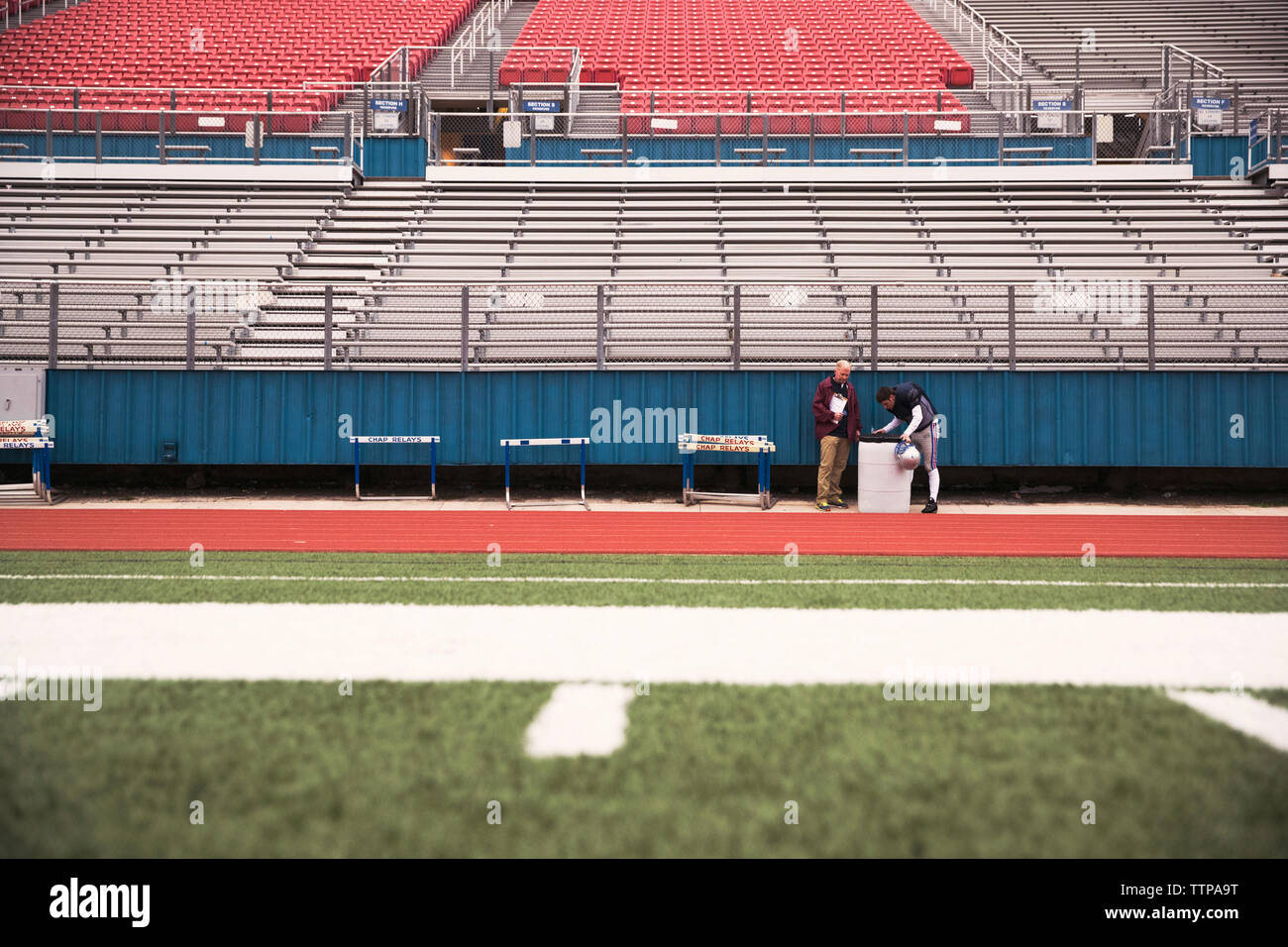 A metà distanza vista di coach e giocatore di football americano a Stadium Foto Stock