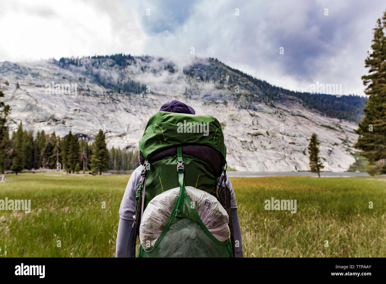 Escursionista che porta uno zaino mentre guardano la montagna nel Parco Nazionale di Yosemite Foto Stock