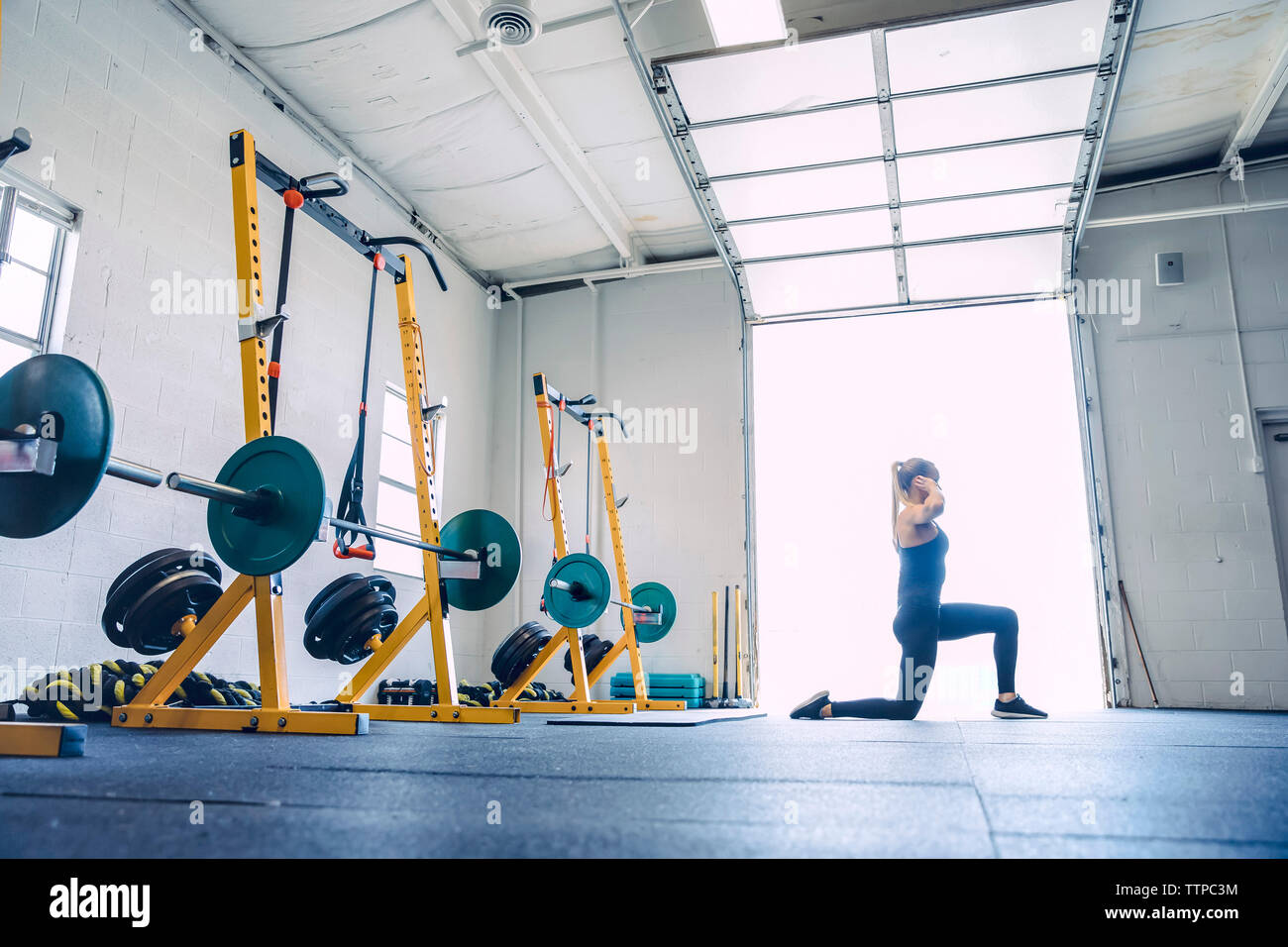 Vista laterale della donna che esercitano nel club salute Foto Stock