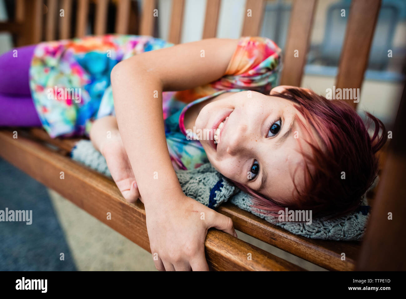 Ritratto di sorridente ragazza distesa su swing a casa Foto Stock