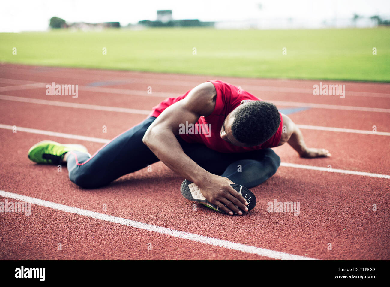 Atleta maschio che esercitano sui binari di scorrimento Foto Stock