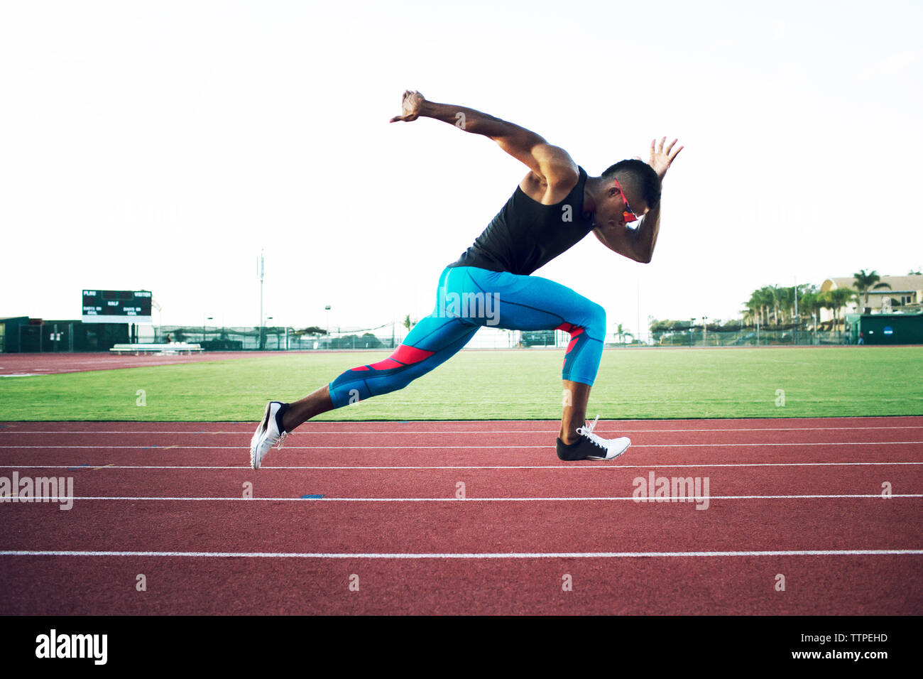 Vista laterale del determinato atleta maschio in esecuzione sul campo Foto Stock