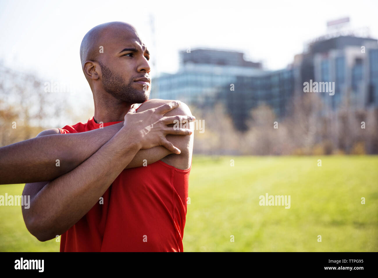 Determinato atleta maschio esercita sul campo in città Foto Stock