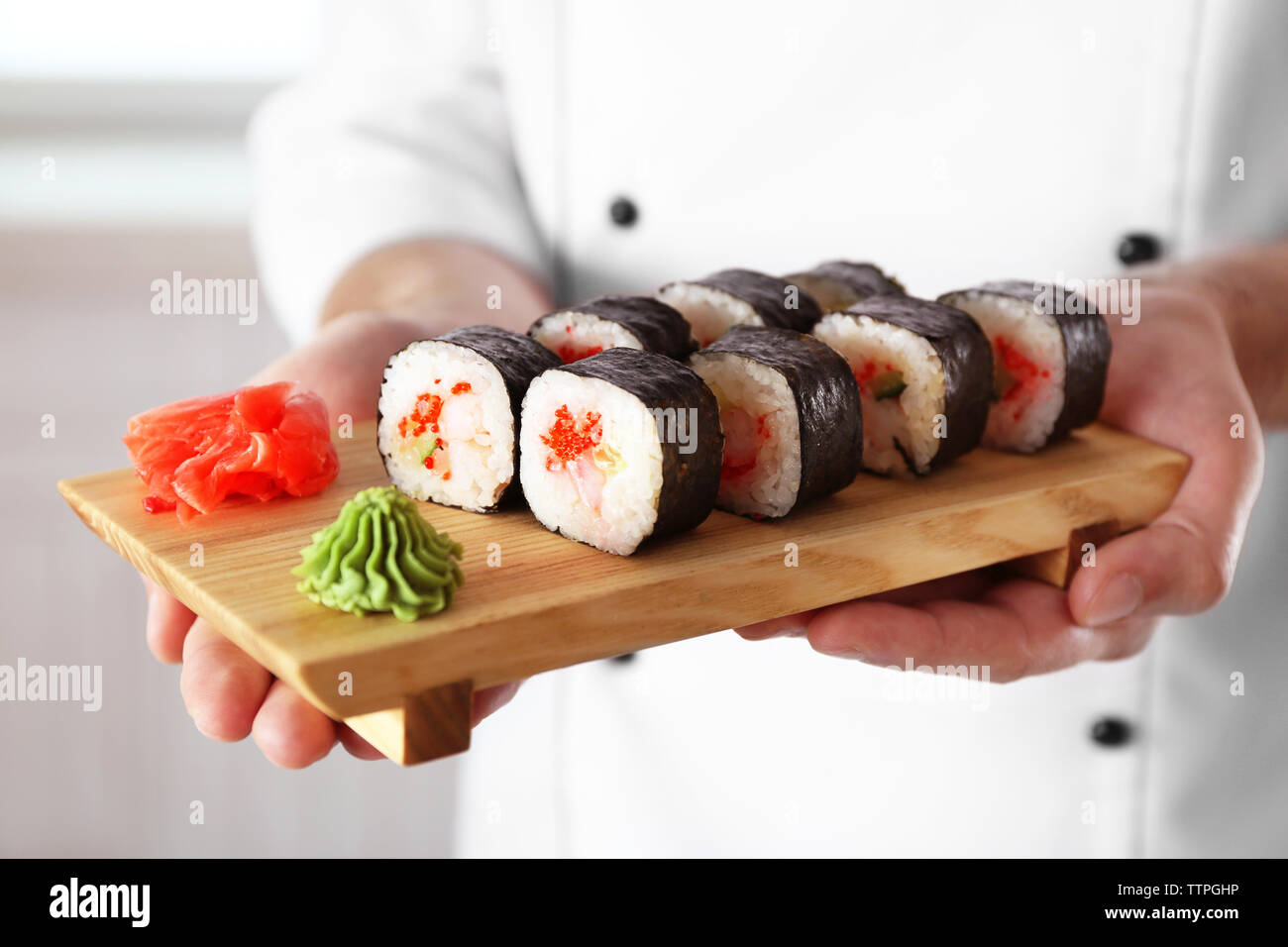 Sushi master azienda tagliere in legno con delizioso sushi set Foto Stock