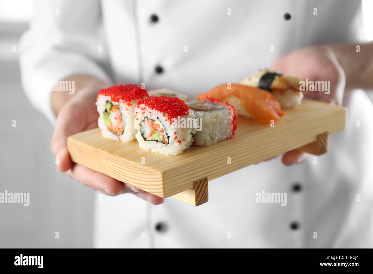 Sushi master azienda tagliere in legno con delizioso sushi set Foto Stock