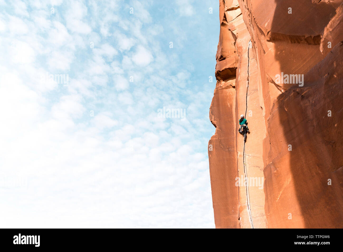 Basso angolo di visione femminile di escursionista salendo sulla montagna contro sky Foto Stock