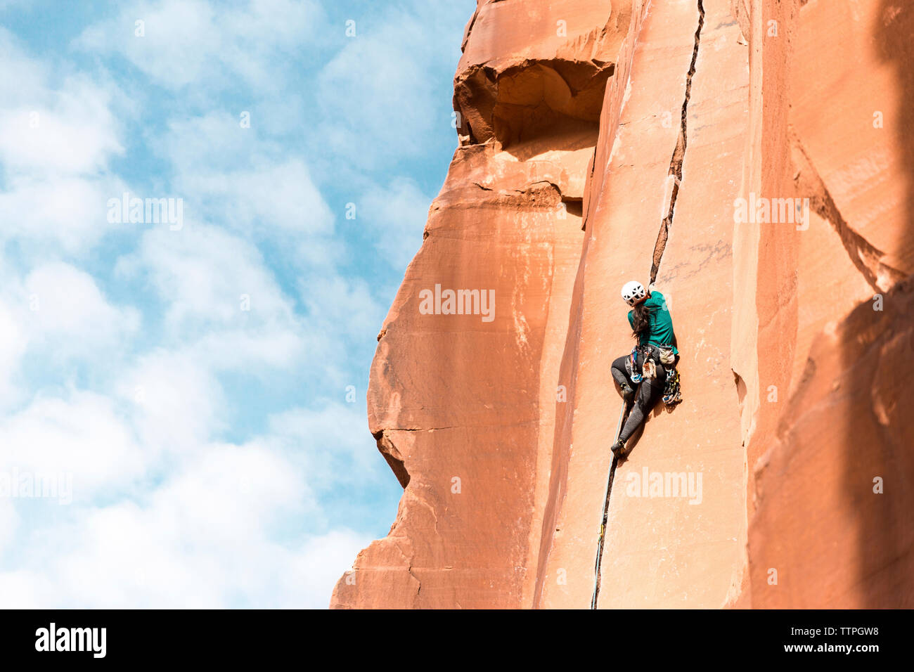 Basso angolo vista posteriore di un escursionista salendo sulla montagna contro sky Foto Stock