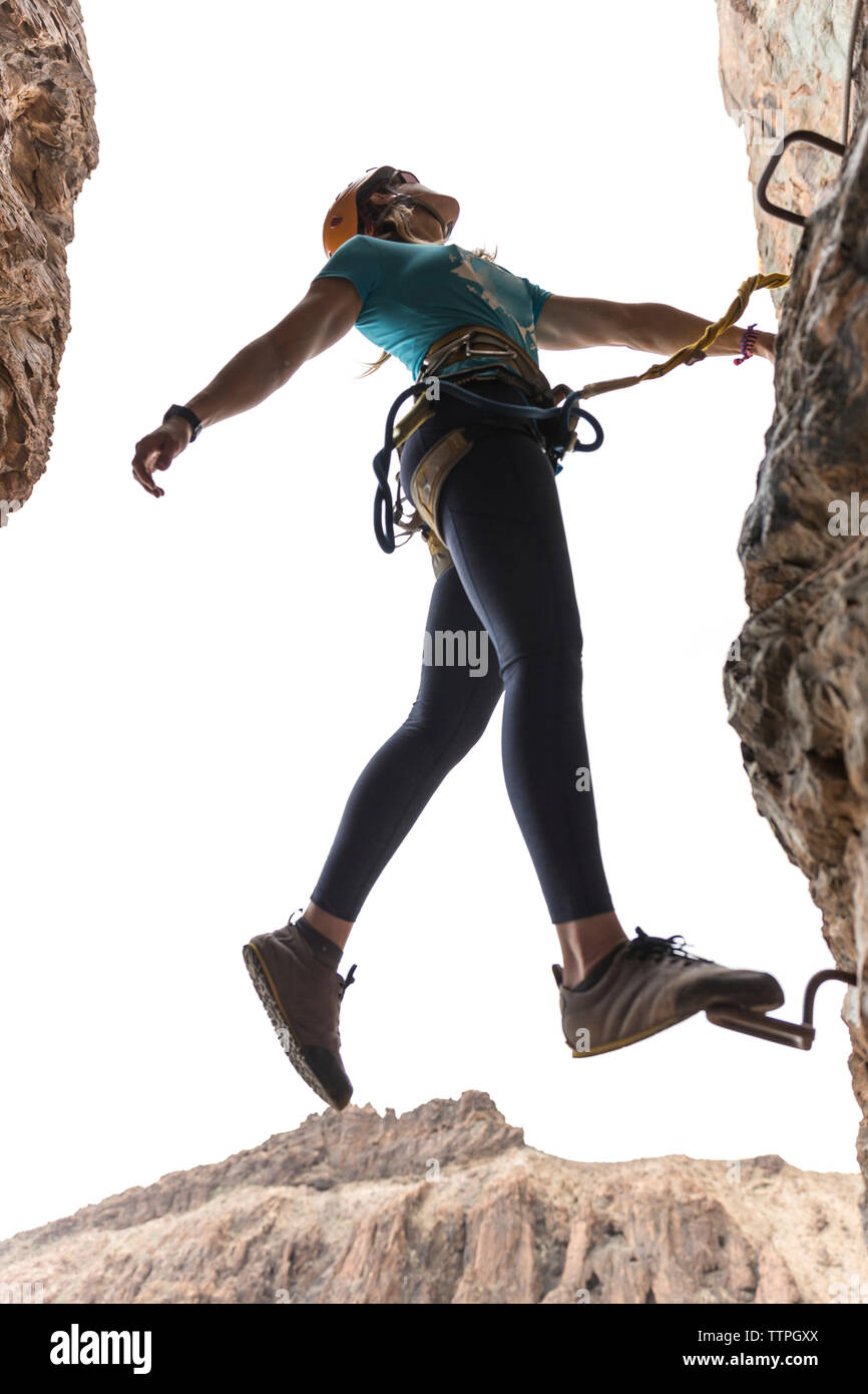 Basso angolo di visione femminile di escursionista in piedi sul gradino montato nella formazione di roccia Foto Stock
