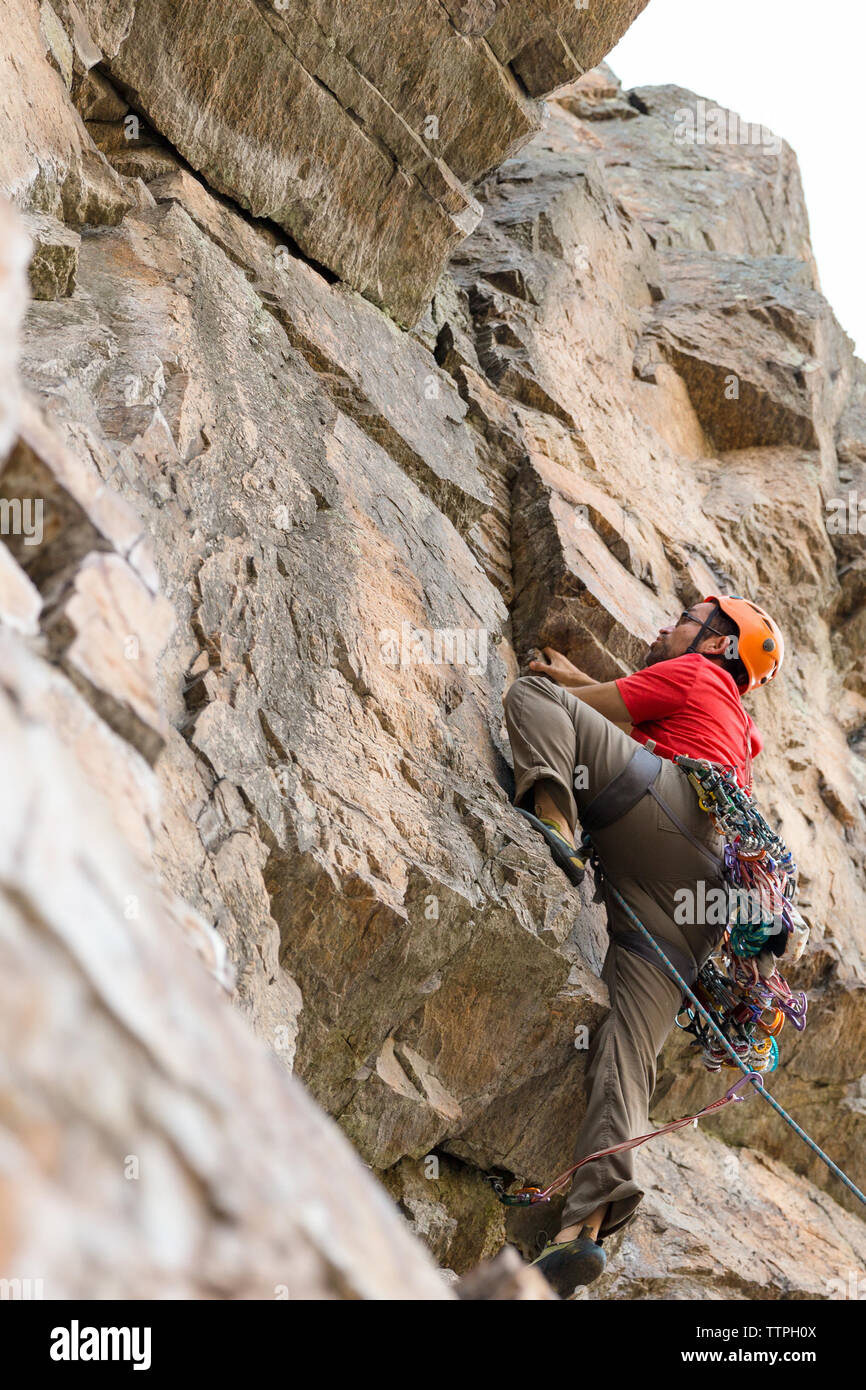 Basso angolo di visione di un escursionista arrampicata su roccia formazione Foto Stock
