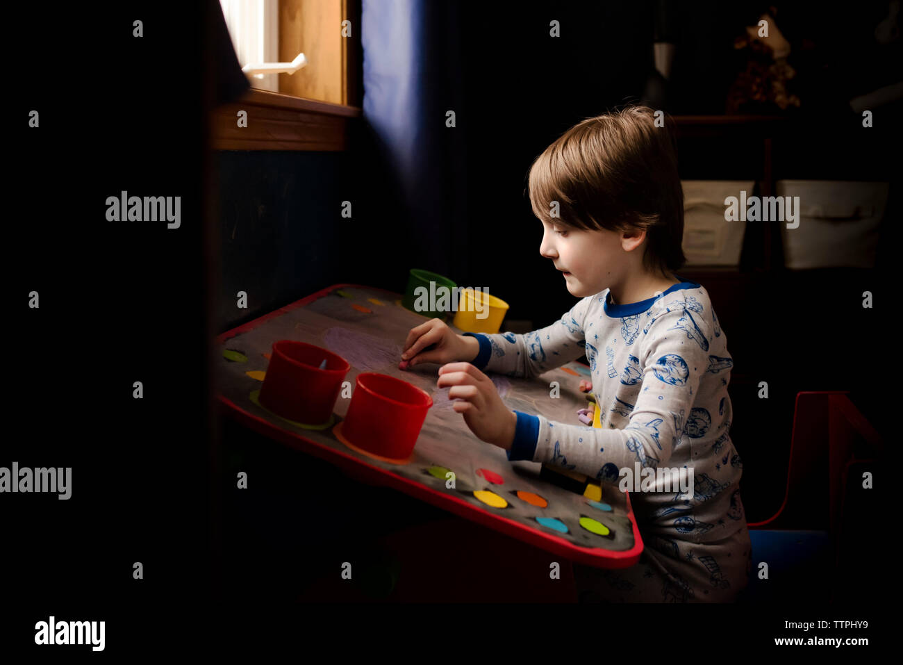 Un piccolo ragazzo che opera su una scheda di Chalk Foto Stock