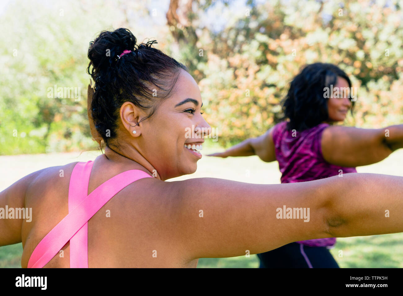 Sportivi con le braccia aperte che esercitano in posizione di parcheggio Foto Stock