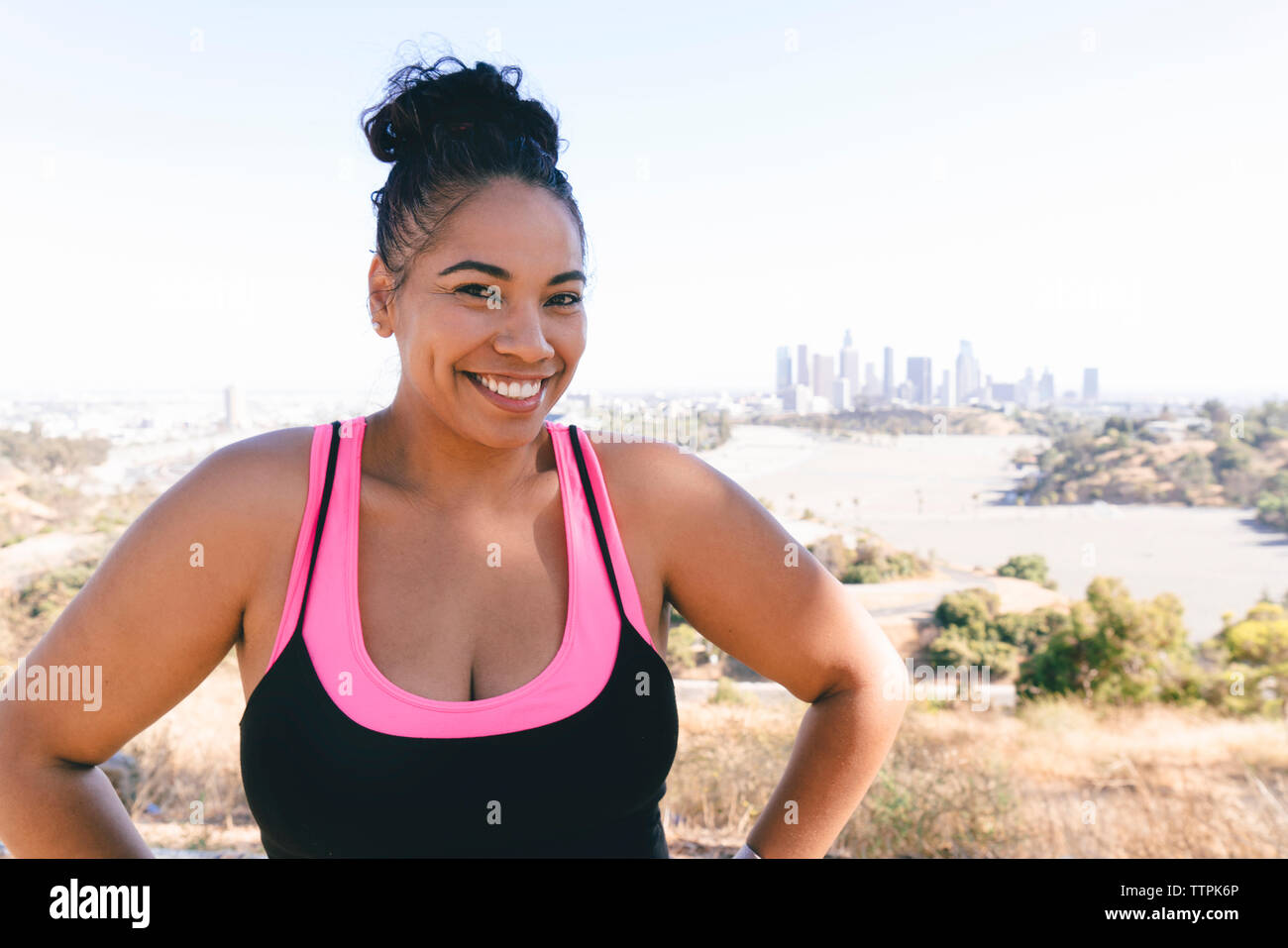 Ritratto di fiducioso sportive in piedi contro il cielo chiaro Foto Stock