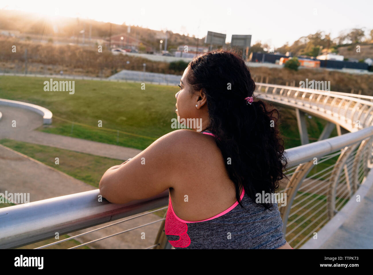 Alta vista angolare di pensosa sportive appoggiata sul parapetto Foto Stock
