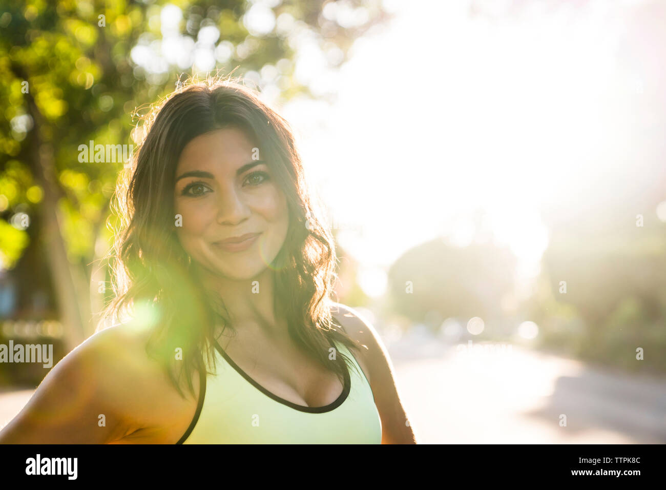 Ritratto di donna fiduciosa mentre ti alleni in parcheggio durante la giornata di sole Foto Stock