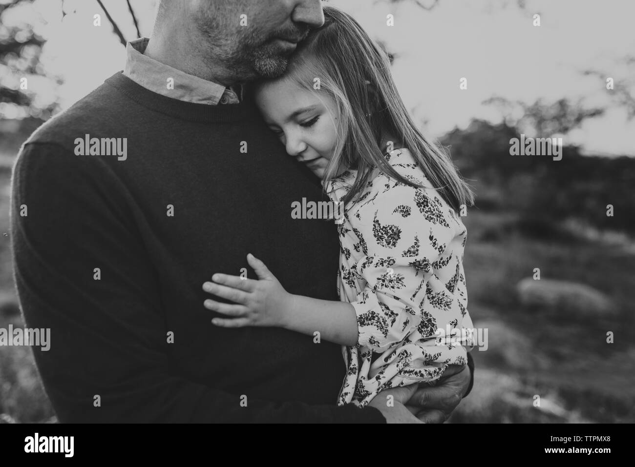 Close up della figlia di essere abbracciati dal padre nel campo della California Foto Stock