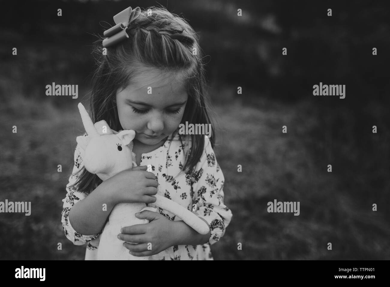 Ritratto di giovane ragazza con animali impagliati toy mentre guardando verso il basso Foto Stock
