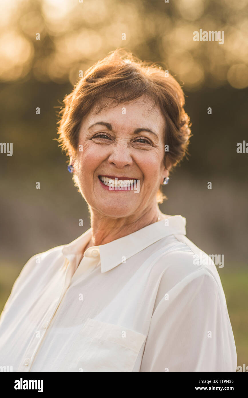 Ritratto di senior donna sorridente in telecamera nel campo retroilluminato Foto Stock
