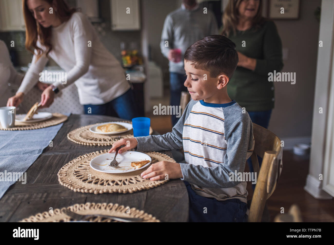 Ragazzo giovane mangiare pancake per colazione Foto Stock