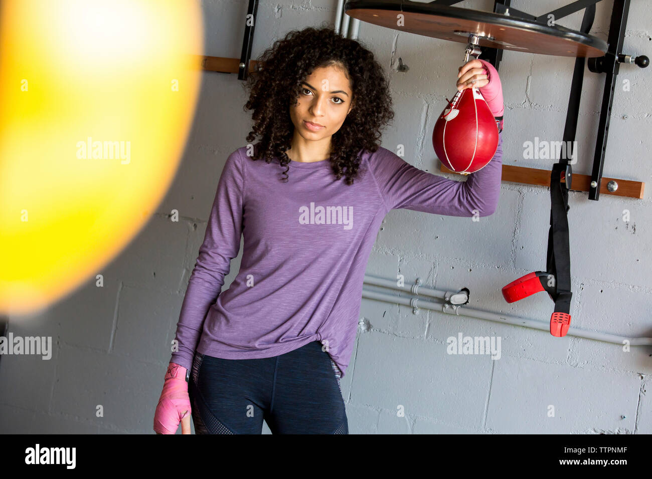 Ritratto di boxer femmina in piedi dalla parete in palestra Foto Stock