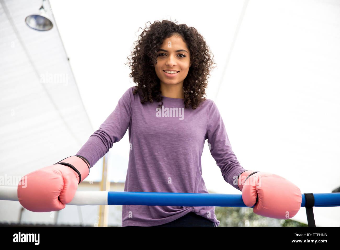 Ritratto di donna sorridente boxer in piedi di pugilato ring Foto Stock