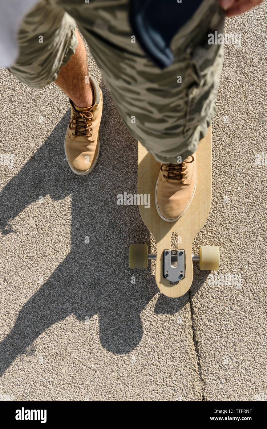 Sezione bassa dell'uomo lo skateboard su strada durante la giornata di sole  Foto stock - Alamy
