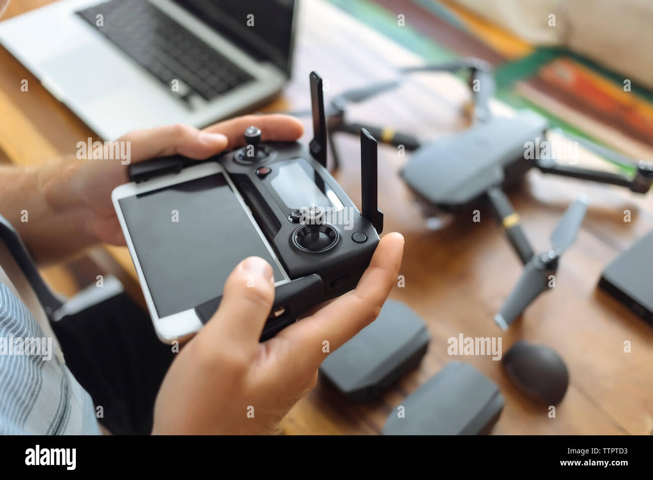 Mani tagliate di ingegnere utilizzando il telefono cellulare con il controllo remoto in ufficio Foto Stock