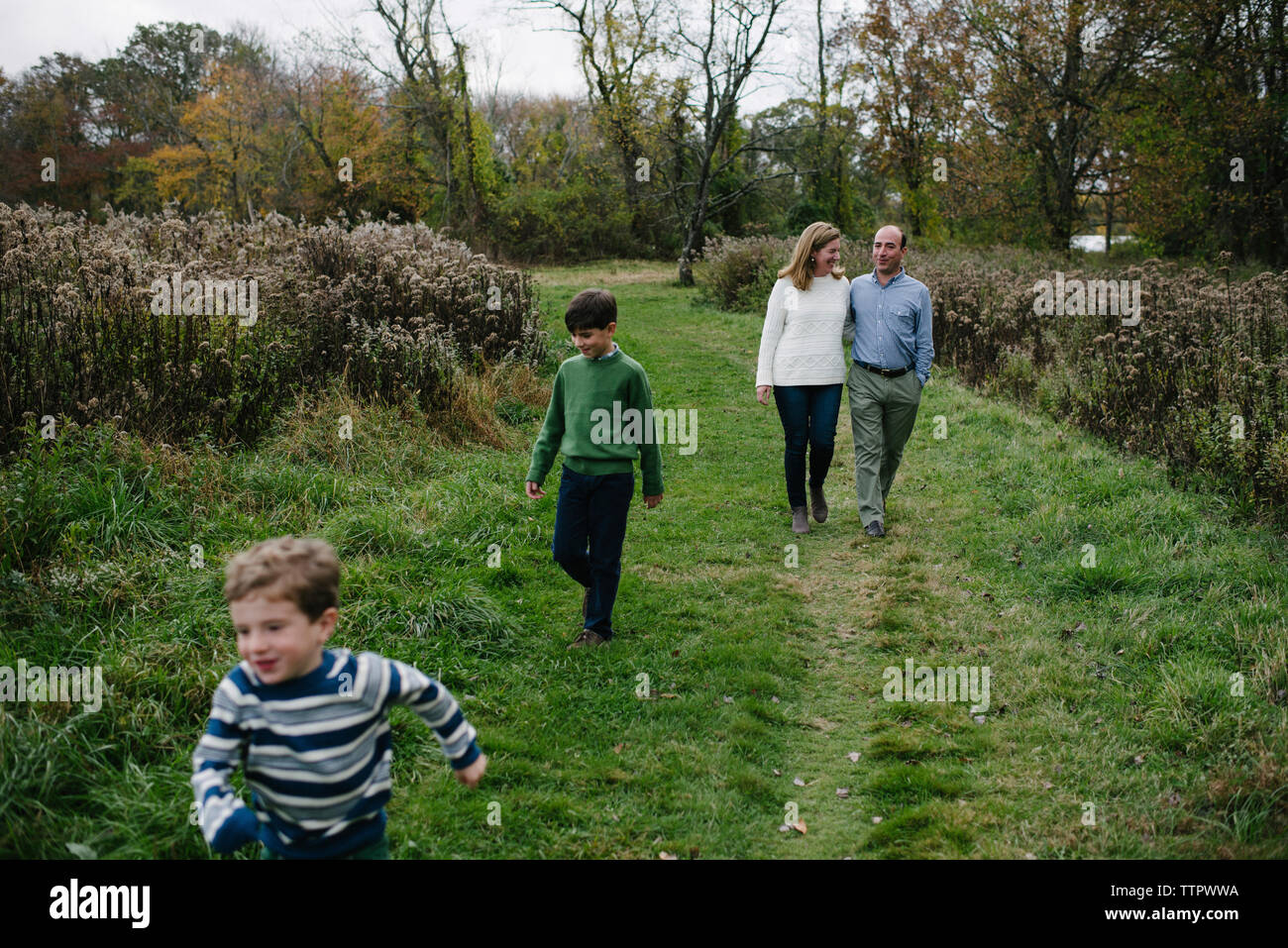 Elevato angolo di visione della famiglia camminando sul campo erboso a park Foto Stock