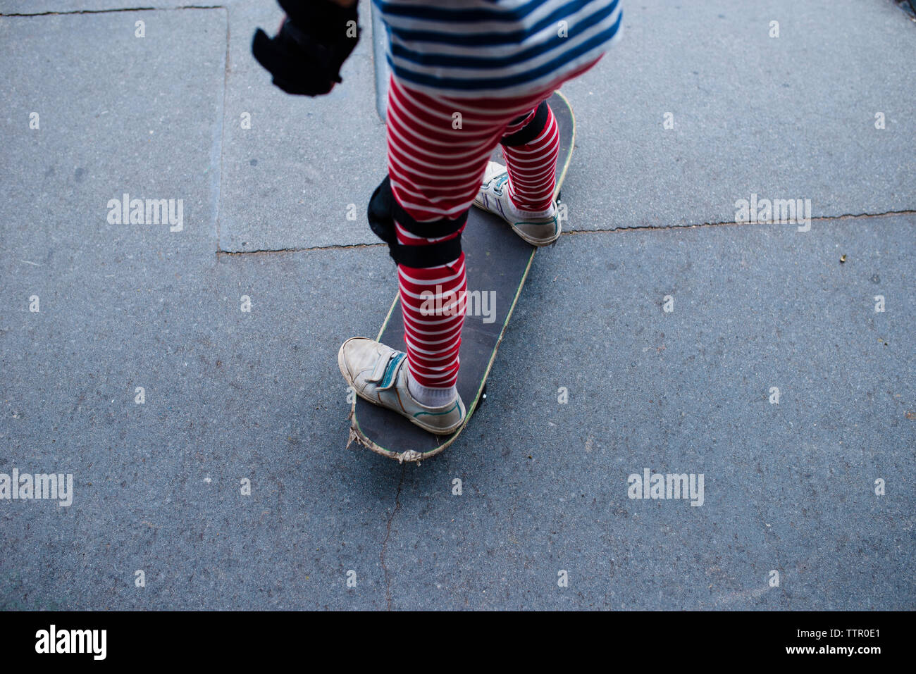 Sezione bassa di boy skateboarding sport sulla rampa in posizione di parcheggio Foto Stock